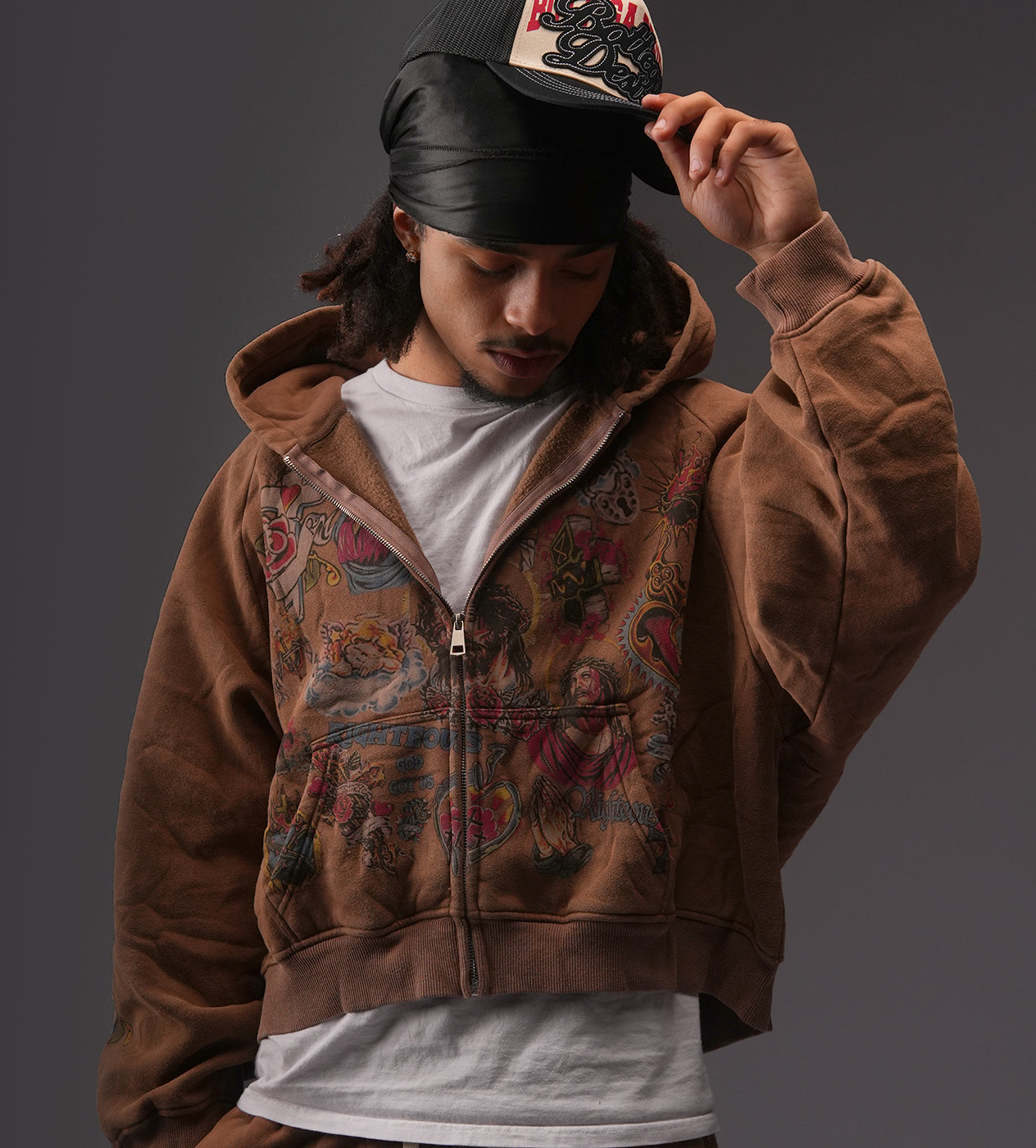 https://cdn.shopify.com/s/files/1/0741/8799/7502/files/Righteous-Risen-King-Zip-Up-Hoodie-Brown-model-2.jpg?v=1766209627